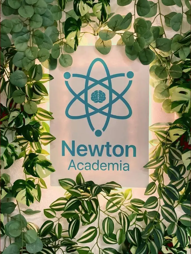 Interior da Academia Newton com o símbolo institucional iluminado